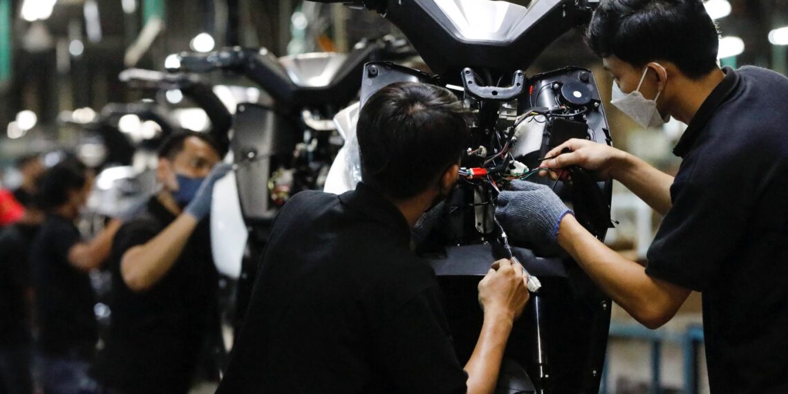 Employees work at the assembly line of an electric motorcycle at the United E-Motor factory in Bogor, near Jakarta, Indonesia, 25 August 2022 (Photo: Reuters/Ajeng Dinar Ulfiana).